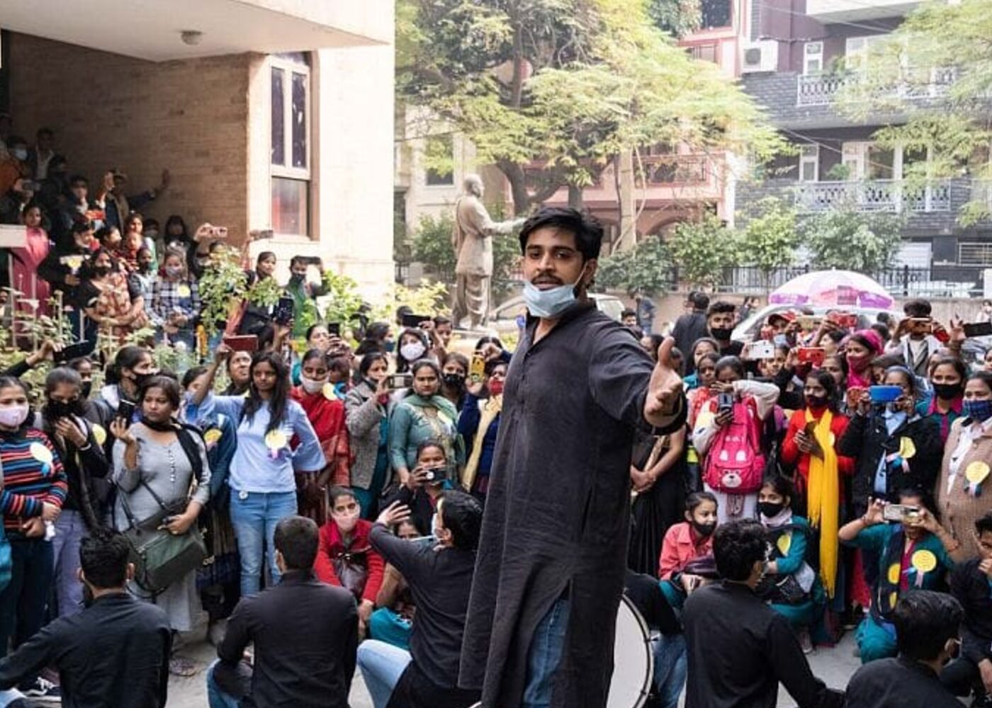 Street theatre performers acting out a scene for a public audience in India